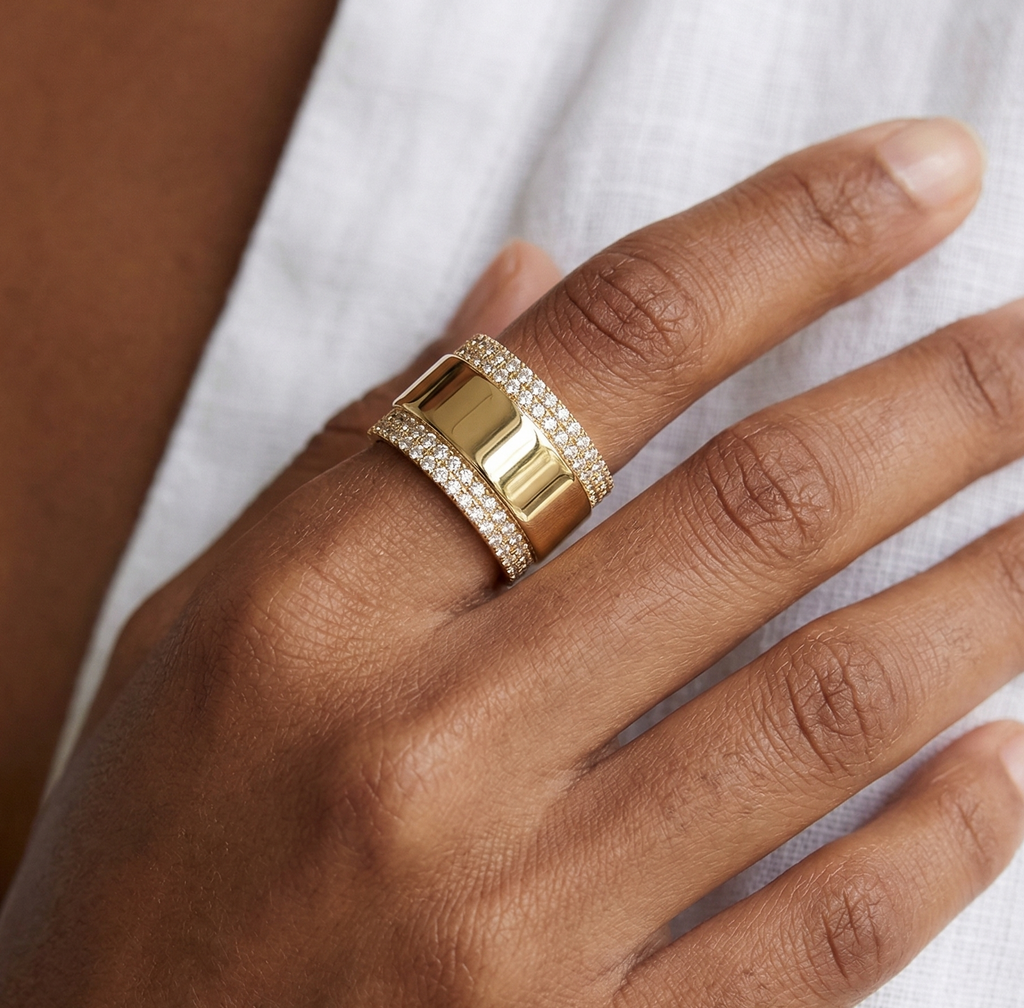 Gold ring on a hand with a white background