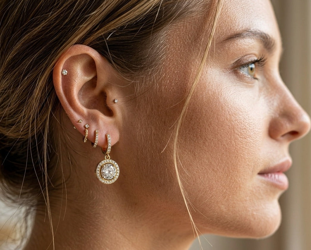 Close-up of a woman's ear with multiple earrings and a blurred background