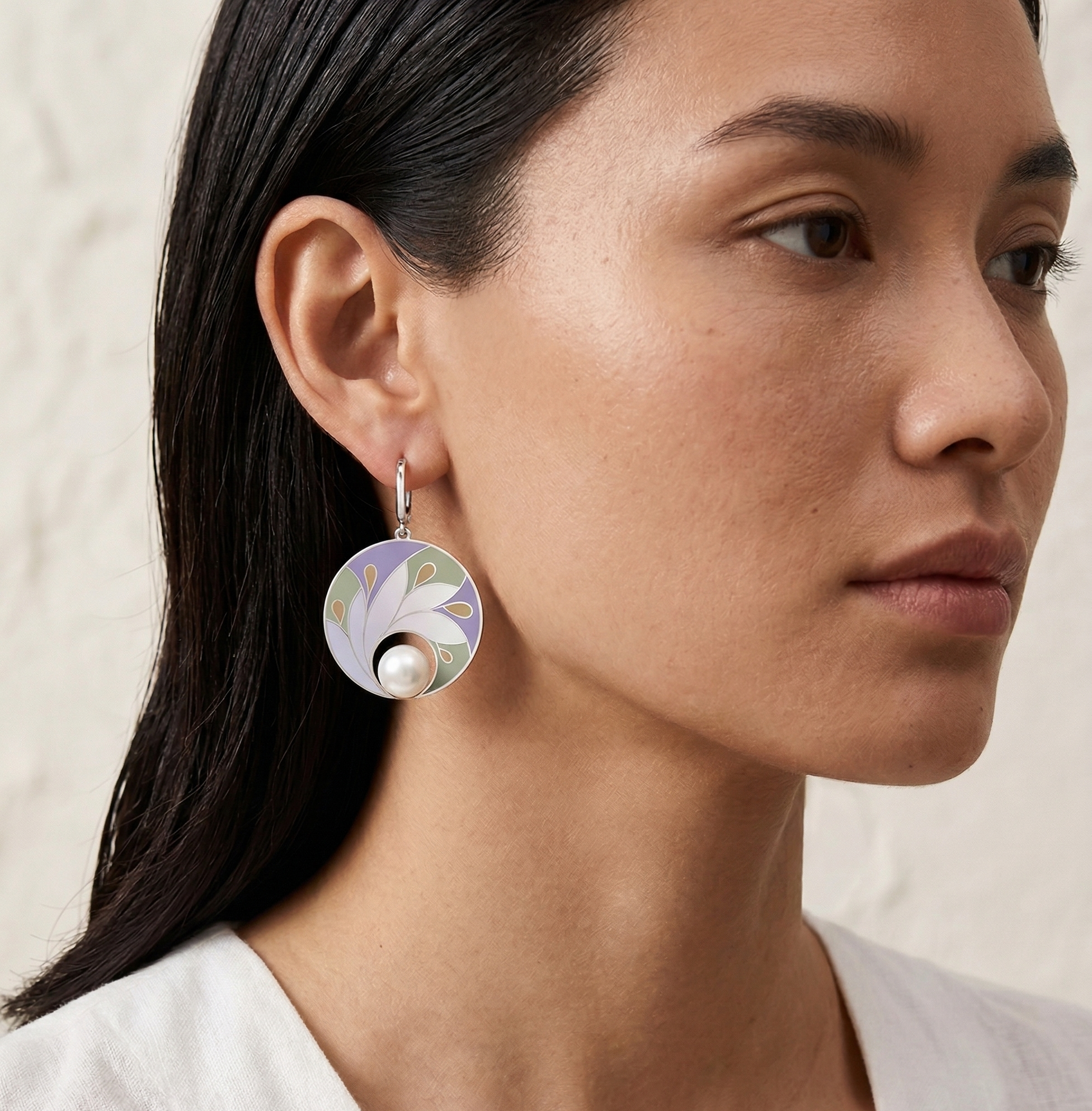 Close-up of a woman wearing a floral earring with a pearl center.