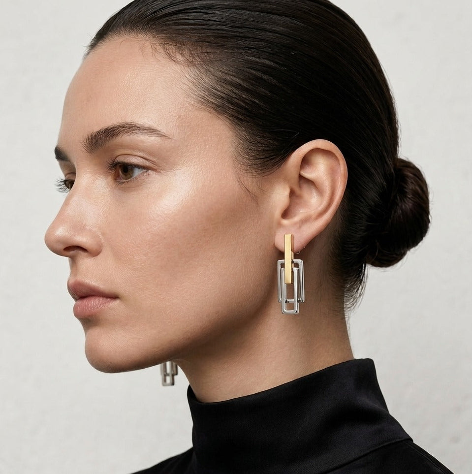 Close-up of a woman wearing a unique earring with a neutral background