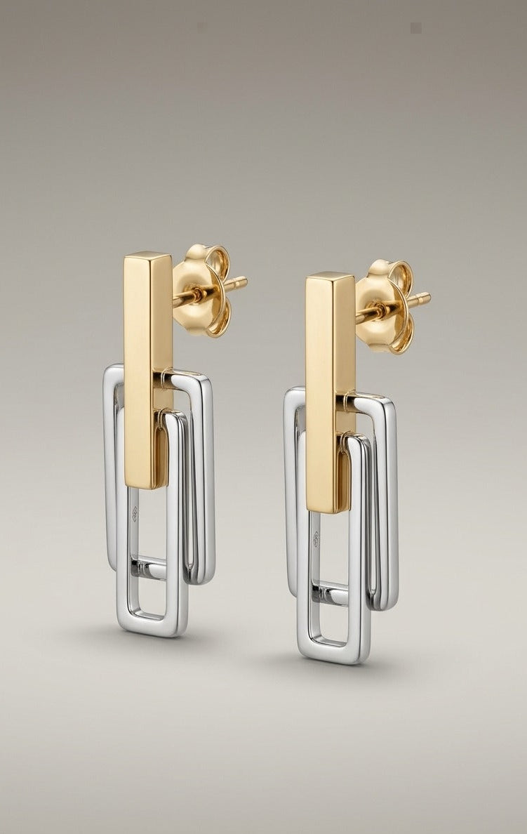 Gold and silver earrings on a light gray background