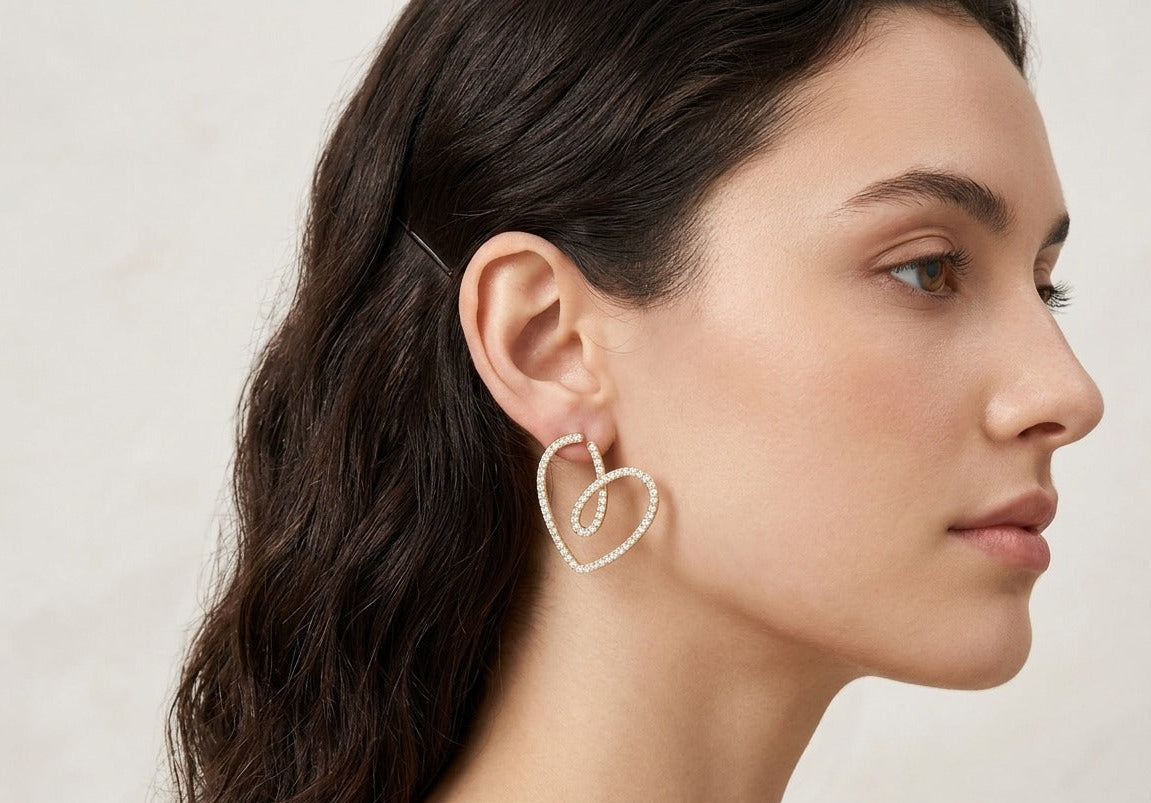 Woman wearing a heart-shaped earring on a neutral background