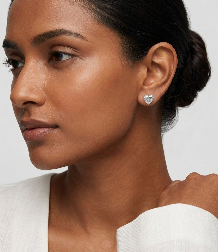 Close-up of a woman wearing a diamond earring on a plain background