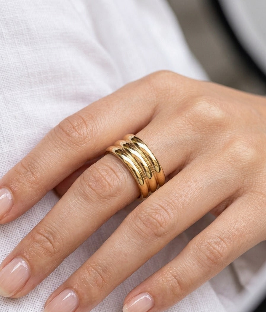 Gold ring on a finger against a white background