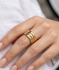 Gold ring on a finger against a white background