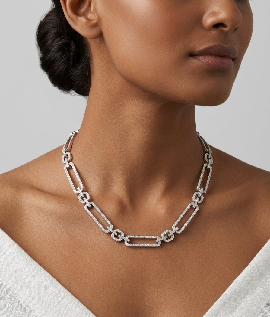Silver chain necklace worn by a model against a neutral background