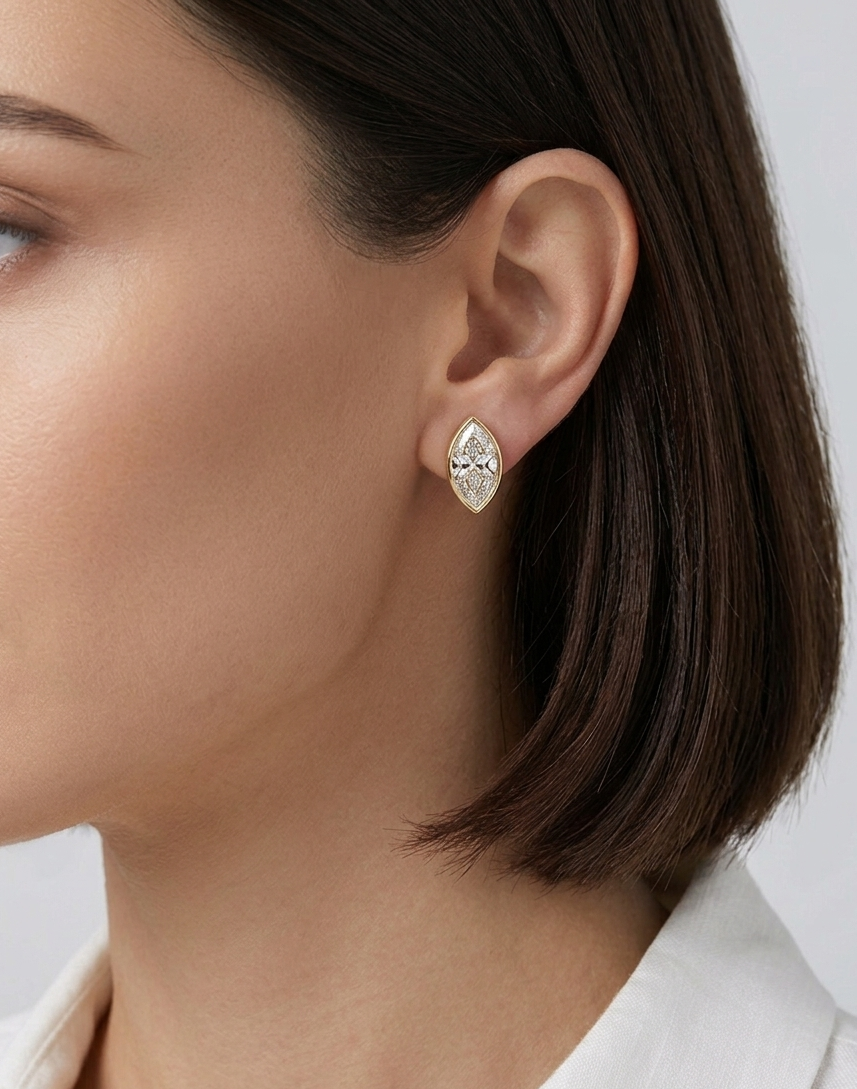 Close-up of a woman wearing a diamond earring on a plain background