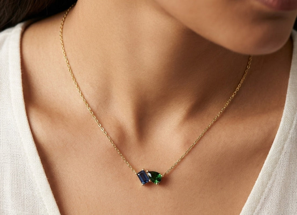 Gold necklace with two gemstones worn by a person