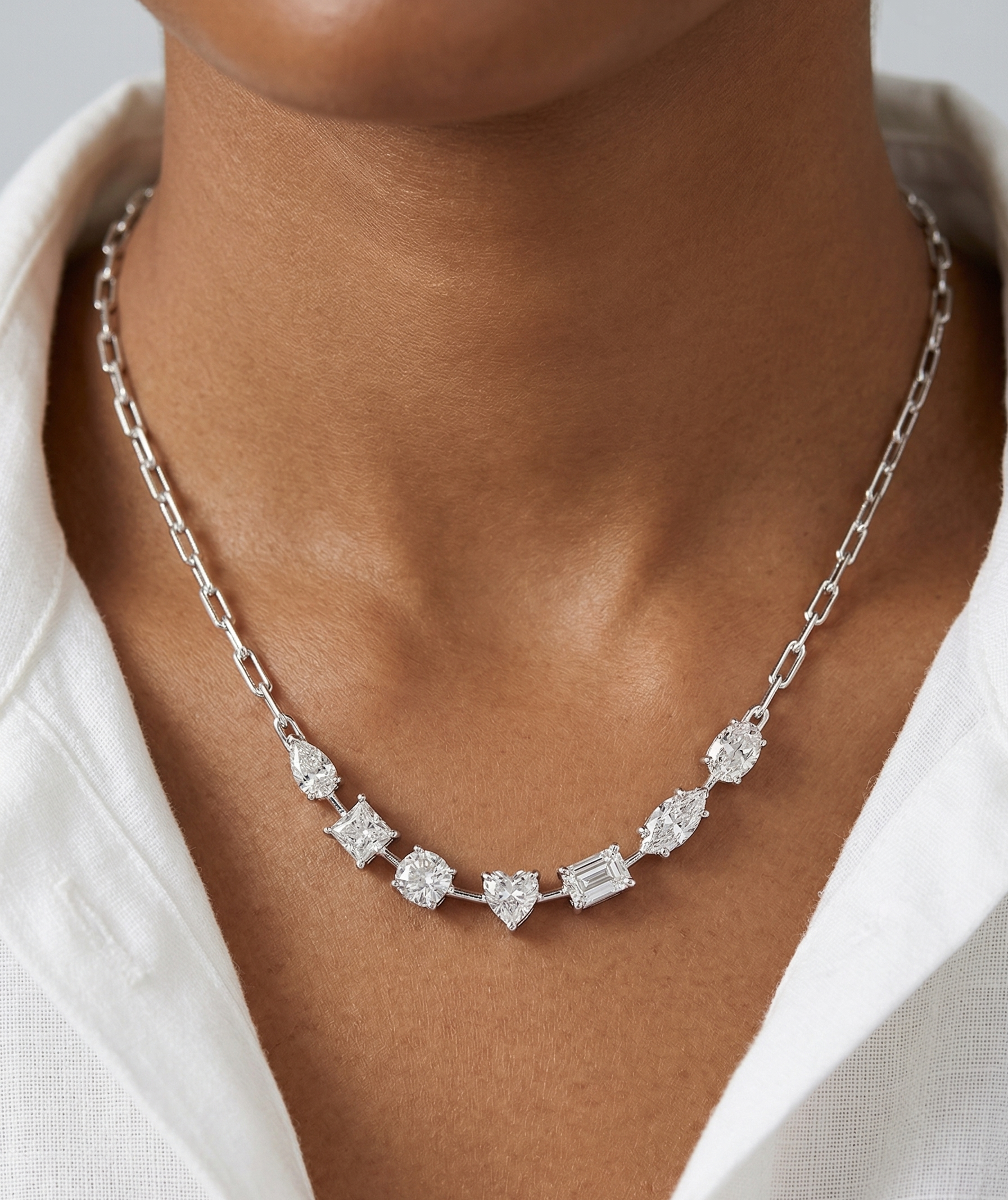 Silver necklace with diamonds on a person wearing a white shirt