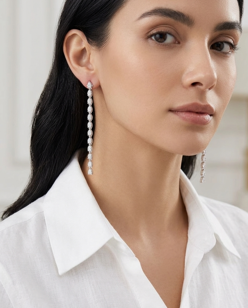 Woman wearing pear earrings with a white shirt against a neutral background