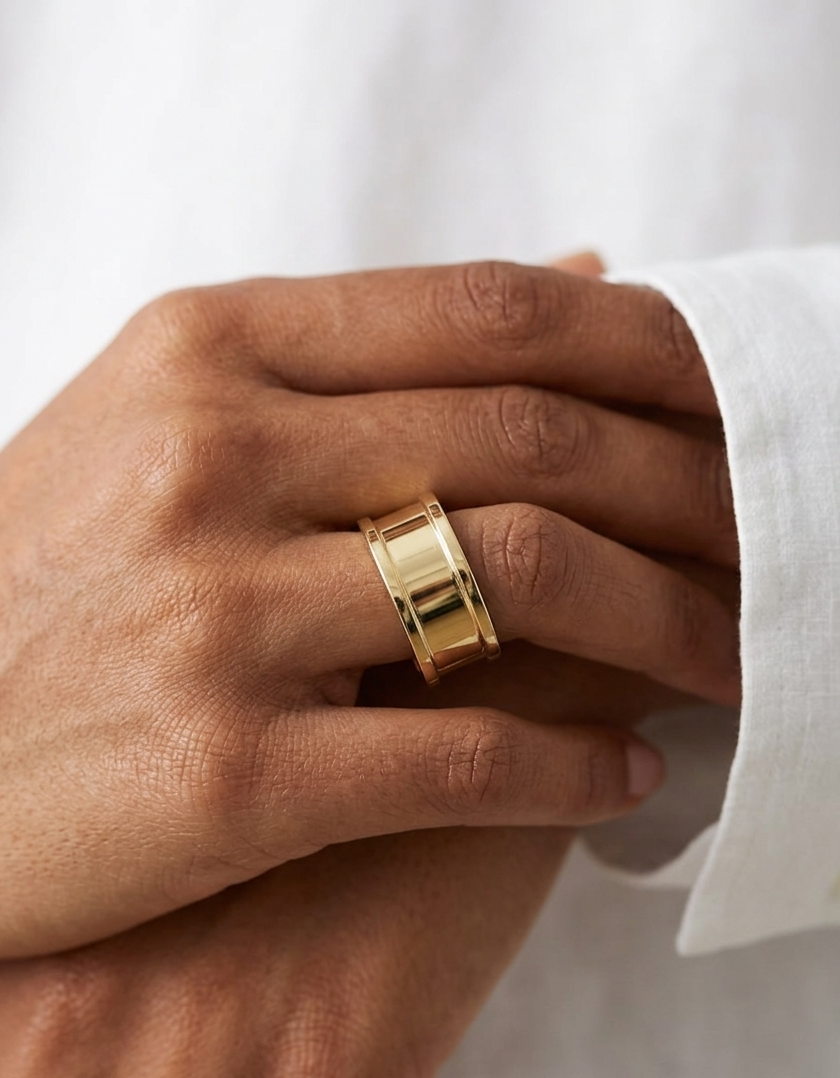 Gold ring on a person's finger against a white background