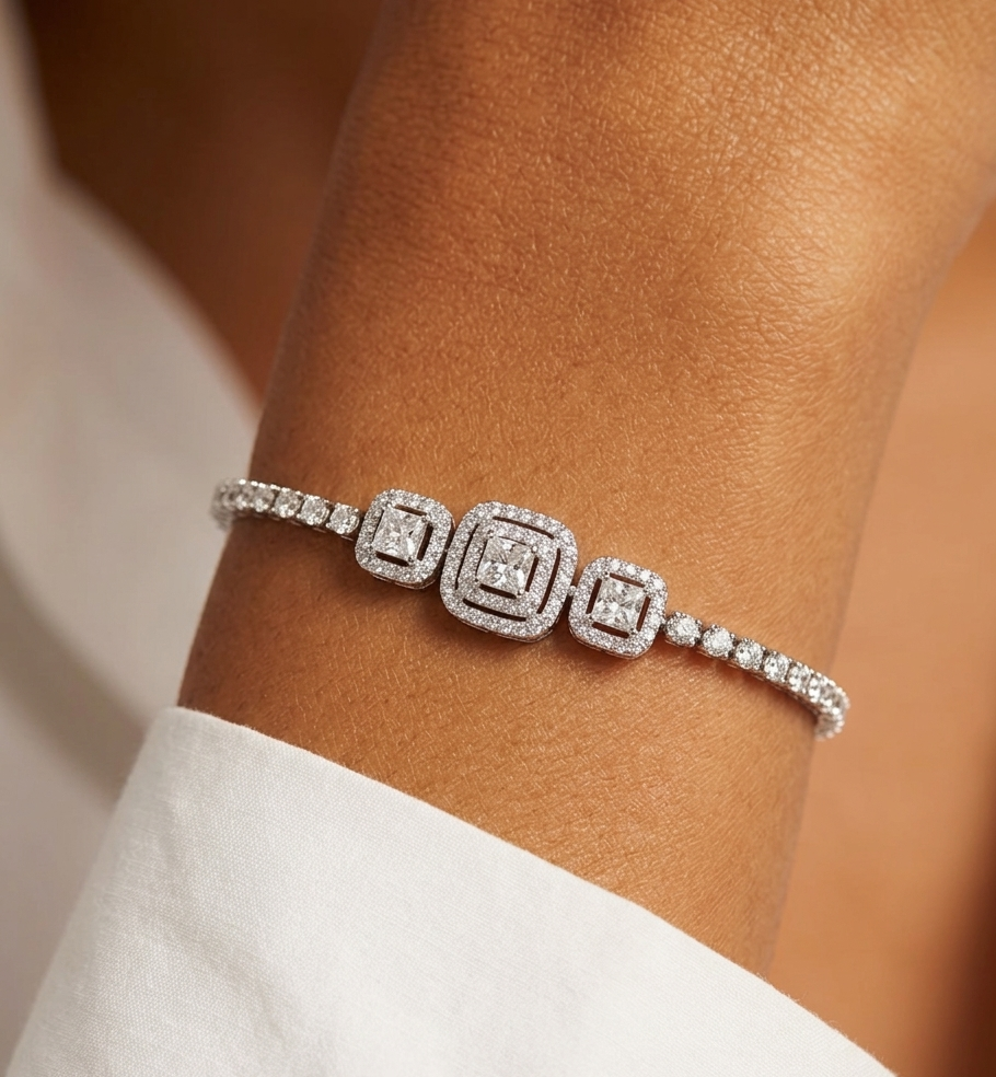 Silver bracelet with square designs on a wrist against a neutral background