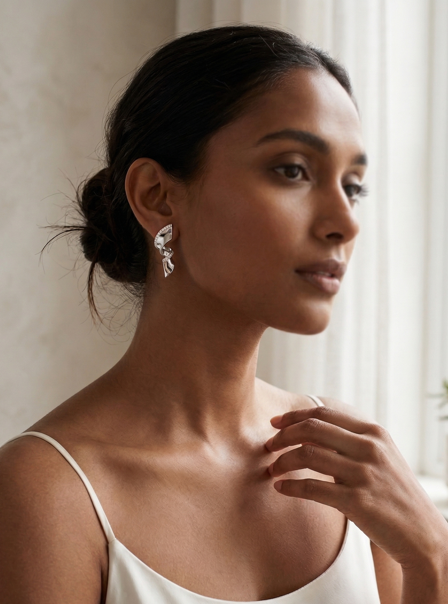 Woman wearing a white sleeveless top with a neutral background