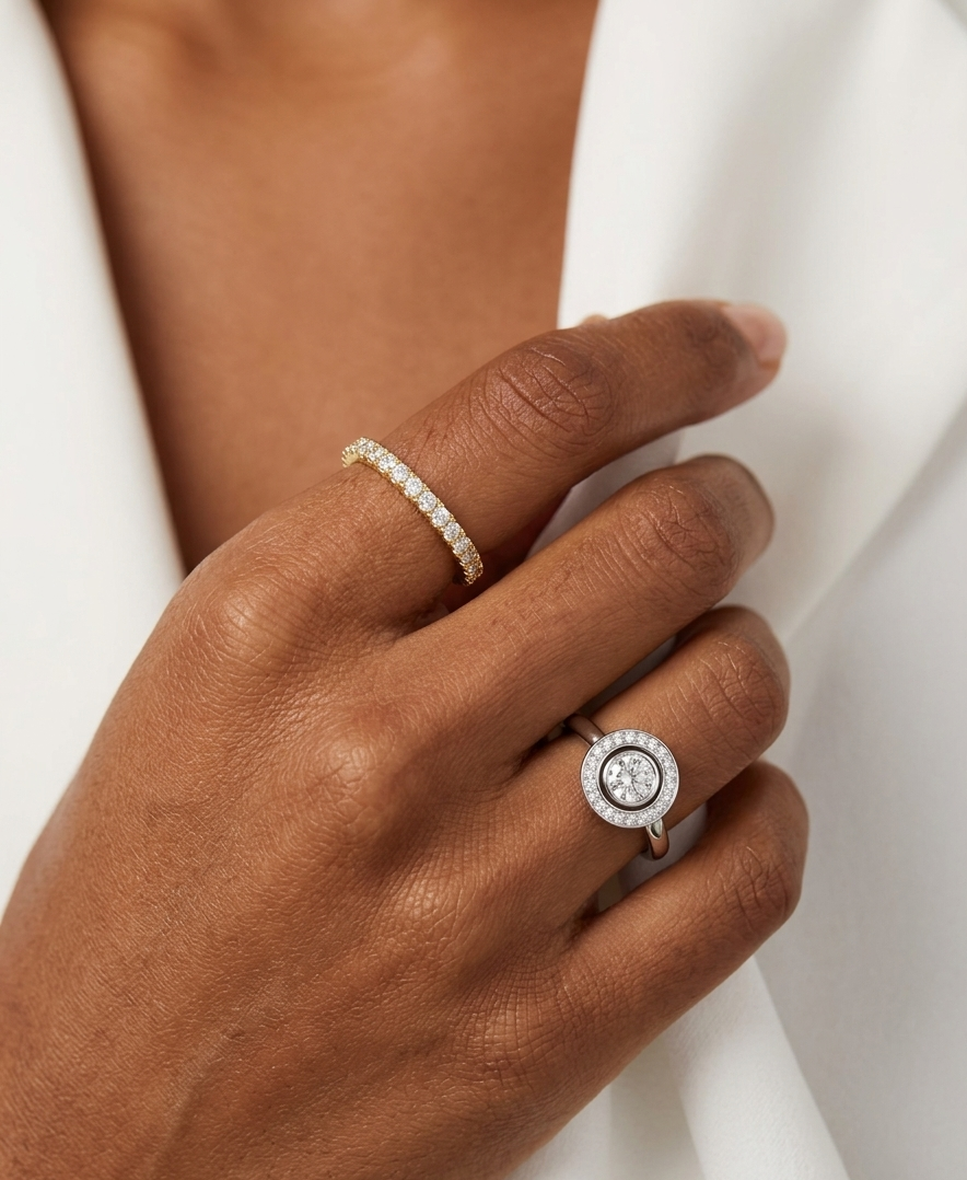Hand wearing two diamond rings on a white background