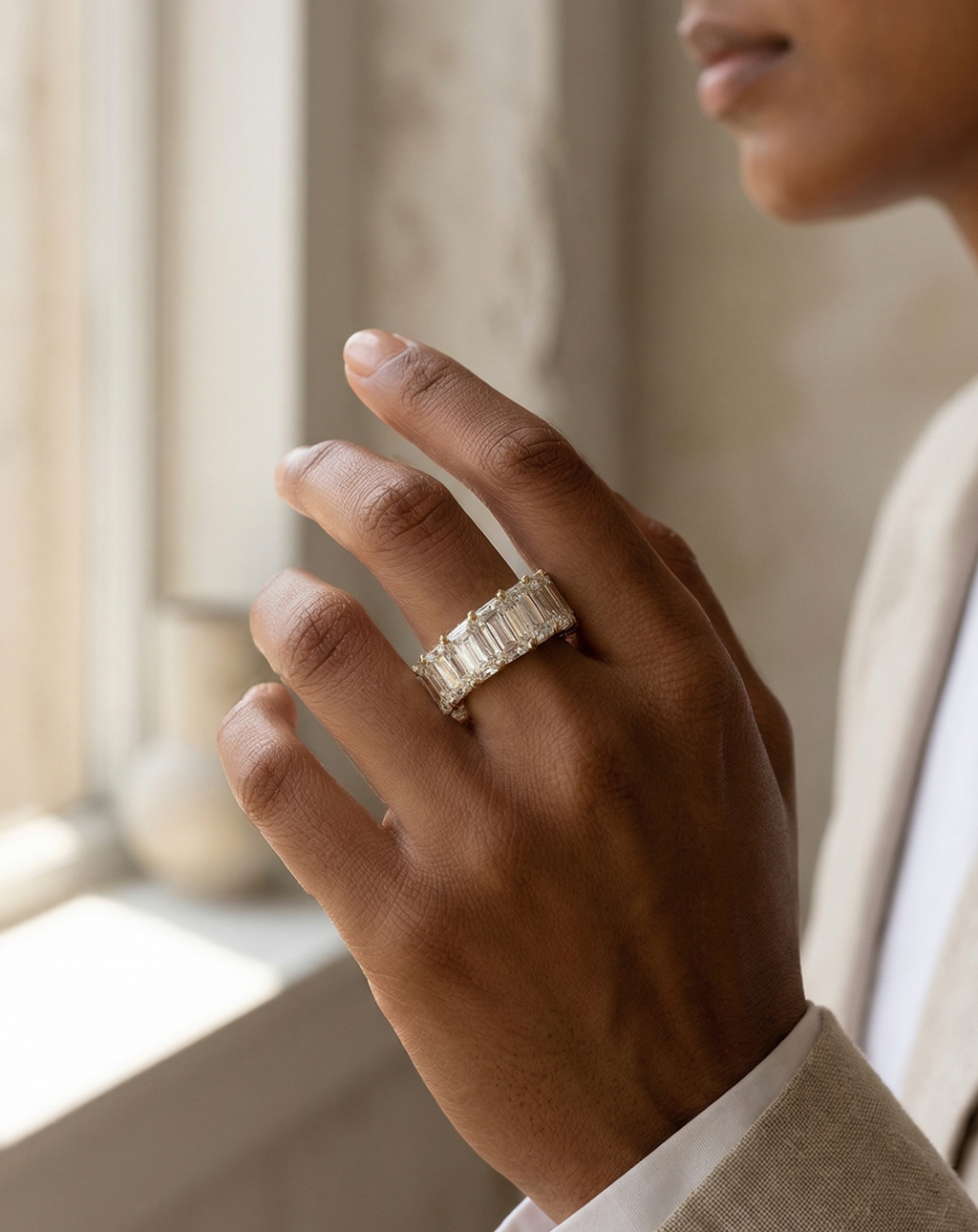 Hand wearing a diamond ring with a blurred background